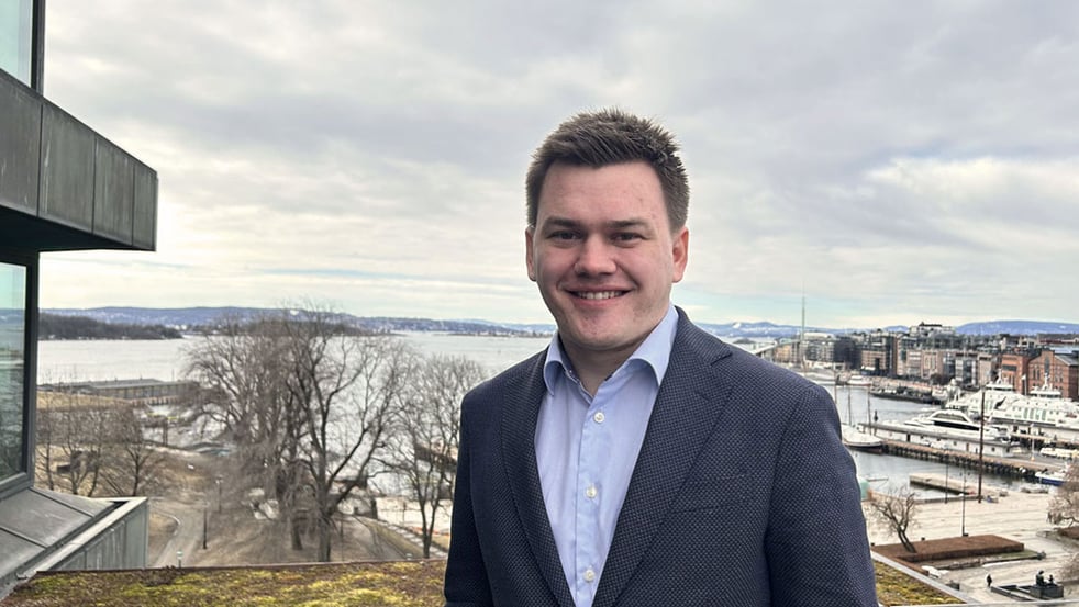 Man on terrace with view of Oslo Aker Brygge behind (photo)